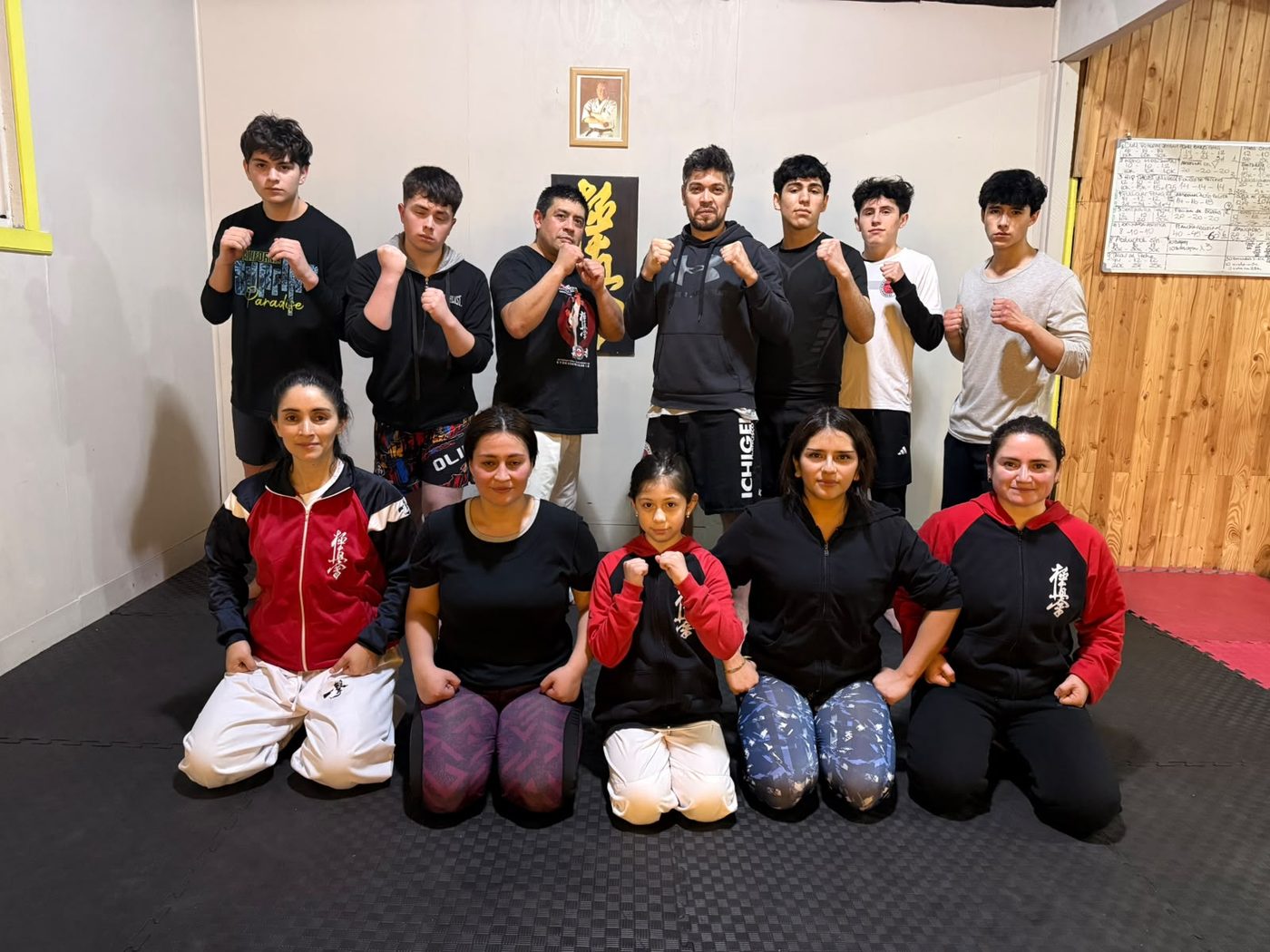 Grupo de Kickboxing Ichigeki en pose de guardia frente al kanji del dojo